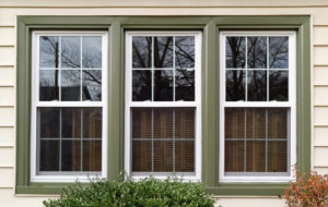 Beautiful house windows with white frames and green trim.
